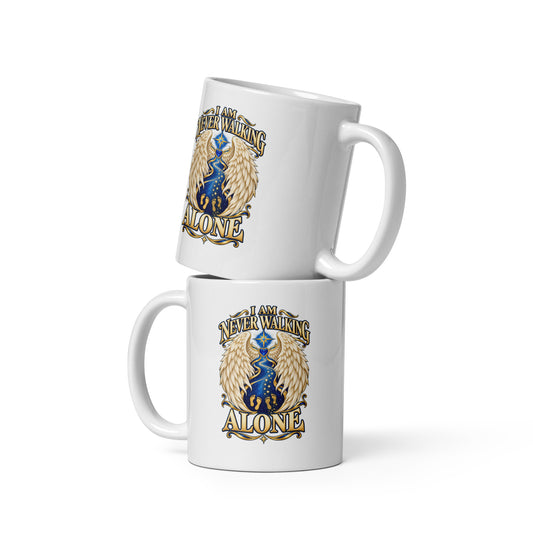 I Am Never Walking Alone design, cream angel wings framing a starry path with two sets of gold footprints and a blue gem heart, on a white glossy mug, 11 oz, front view