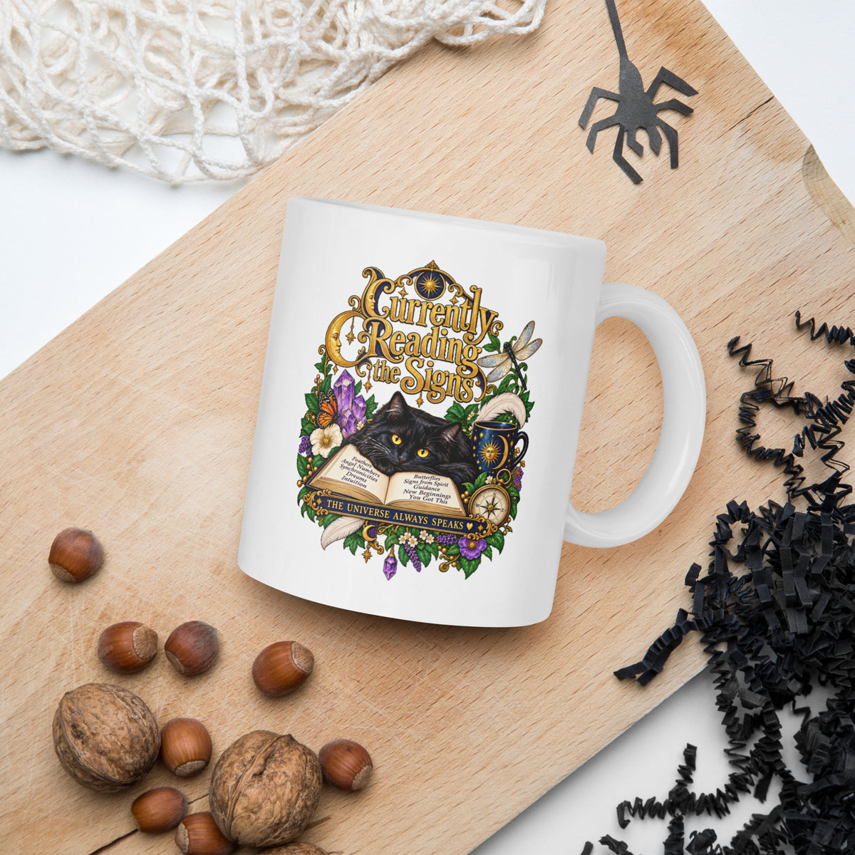 Currently Reading The Signs dark academia design, two black cats asleep over an open book beneath a crescent moon, on a white glossy mug, 11 oz, in a Halloween scene