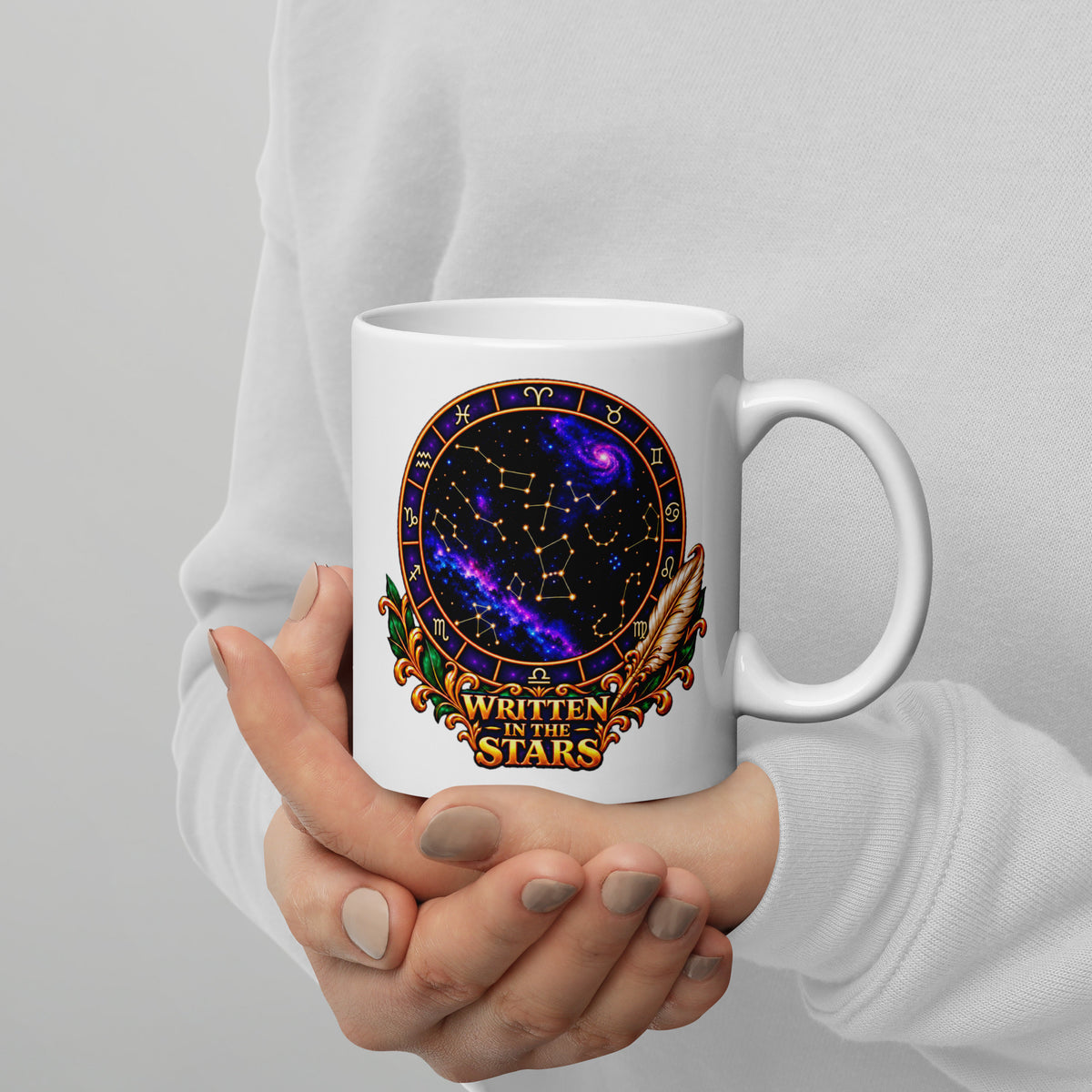 Written In The Stars astrology design, a zodiac wheel of constellations and a galaxy framed by gold scrollwork and a feather quill, on a 11 oz white glossy mug, handle on the right