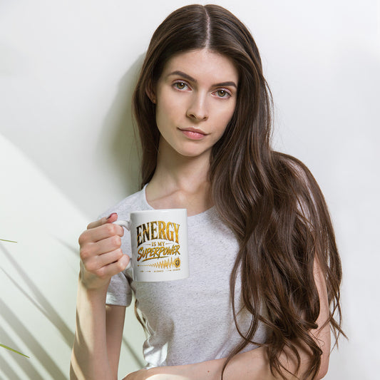 Energy Is My Superpower design in gold, on a white glossy mug, 11 oz, held by a model