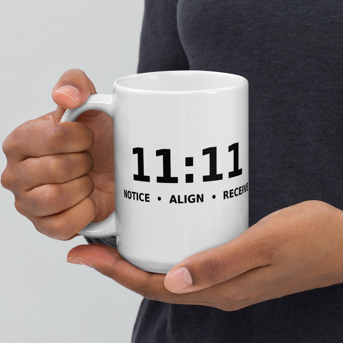 11:11 angel number design, the number set in plain white type above Notice, Align, Receive, on a white glossy mug, 15 oz, handle on the left