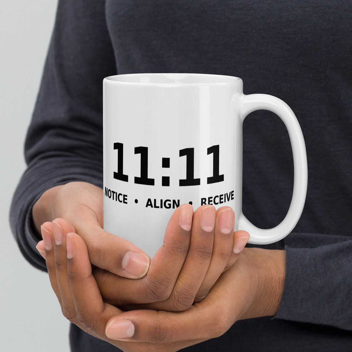 11:11 angel number design, the number set in plain white type above Notice, Align, Receive, on a white glossy mug, 15 oz, handle on the right