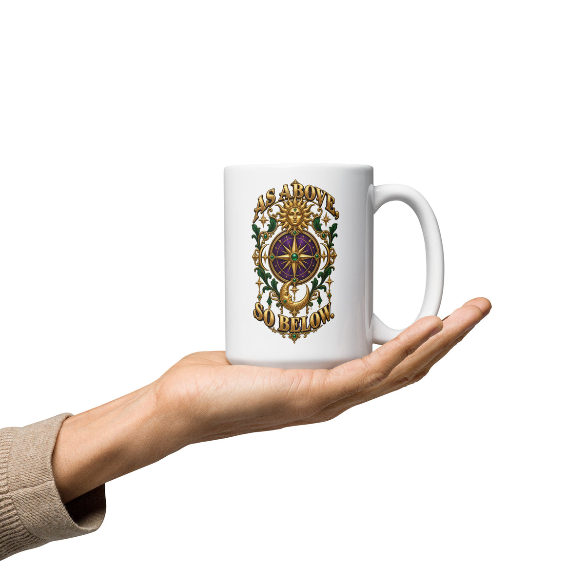 As Above, So Below astrology design, a gold sun face above a purple and gold compass rose with a crescent moon below, framed by emerald foliage, on a 15 oz white glossy mug, handle on the right