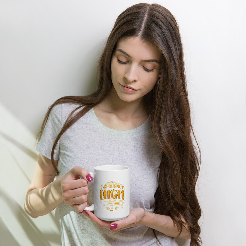 Frequency High design in gold, on a white glossy mug, 15 oz, held by a model