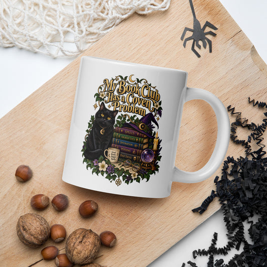 My Book Club Has A Coven Problem dark academia design, a witchy black cat, a crystal ball and a stack of spellbooks, on a white glossy mug, 20 oz, in a Halloween scene