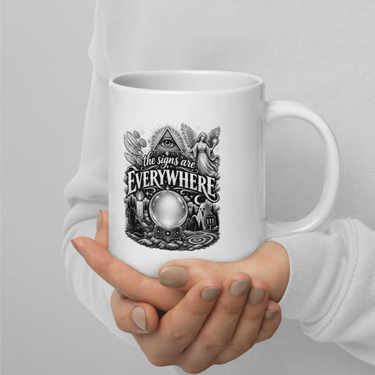 The Signs Are Everywhere design, an all-seeing eye, an angel, a crystal ball, a black cat and a 111 road sign, in black and white line art, on a white glossy mug, 20 oz, handle on the right