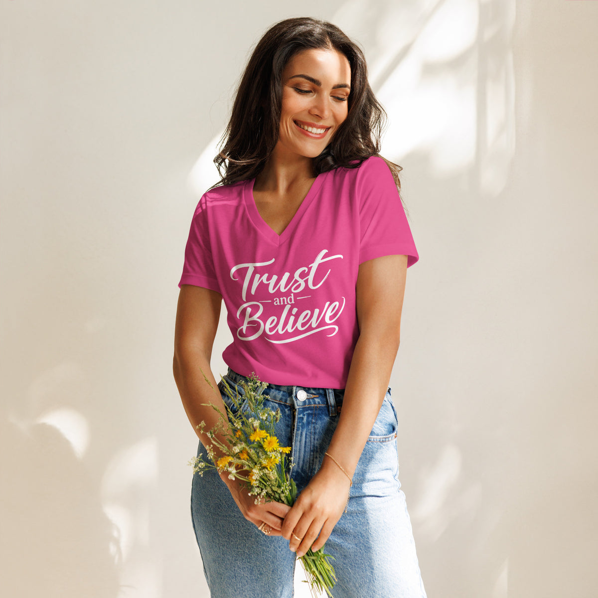 Trust and Believe design in white lettering, on a berry women's relaxed v-neck t-shirt, front view